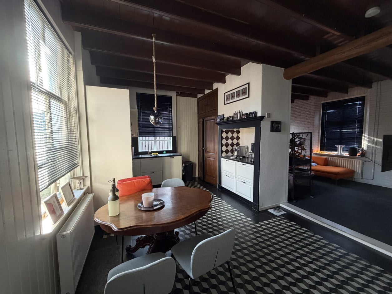 Foto van een landelijke woning met metselwerk en een zadeldak. De ramen hebben klassieke luiken