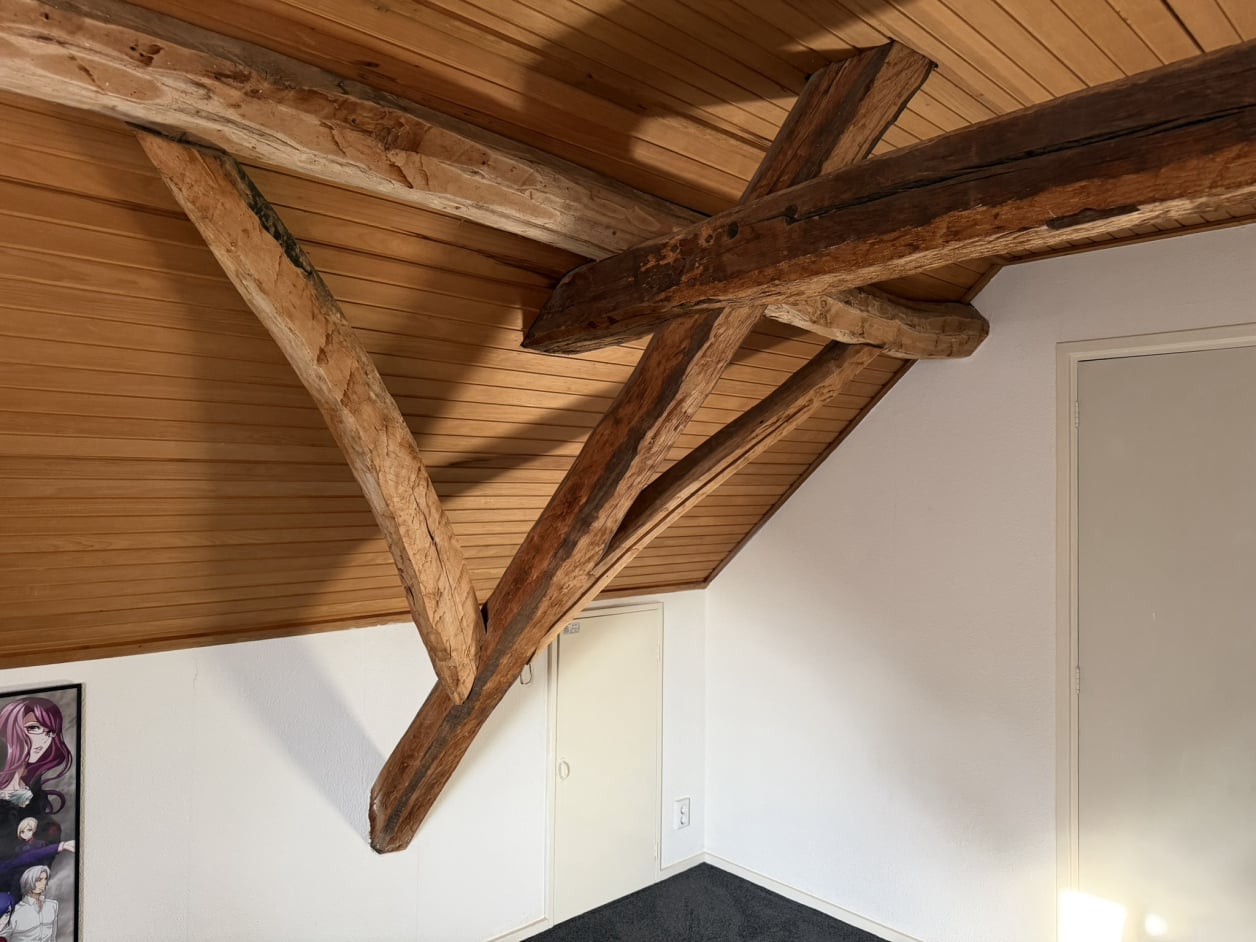 Foto van een landelijke woning met metselwerk en een zadeldak. De ramen hebben klassieke luiken